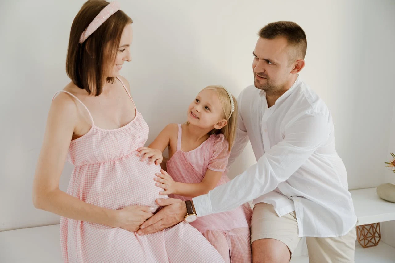 Happy family cherishing a special moment with the expectant mother indoors.